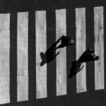 people on crosswalk in black and white