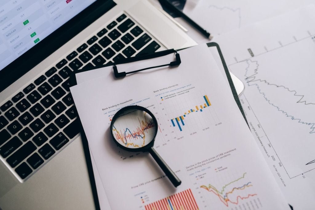 magnifying glass on white paper with statistical data